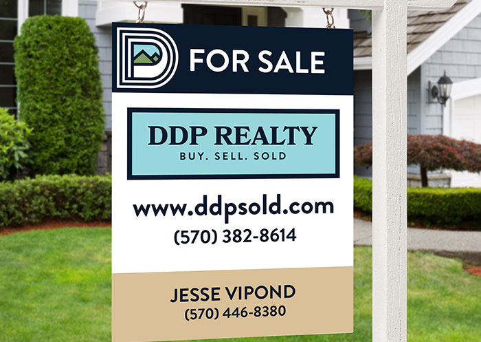 For Sale sign with DDP Realty branding in the yard of a house.