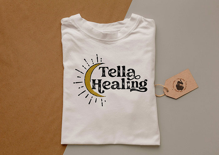 The Tella Healing logo on a white, folded t-shirt.